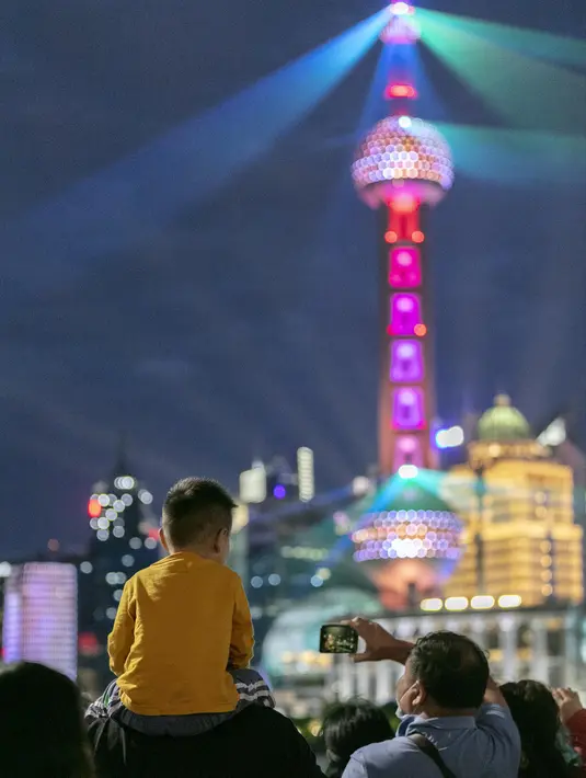 Orang-orang menikmati pertunjukan cahaya di Bund, Shanghai, China timur, pada 5 Oktober 2020, hari kelima libur Hari Nasional dan Festival Pertengahan Musim Gugur. (Xinhua/Wang Xiang)
