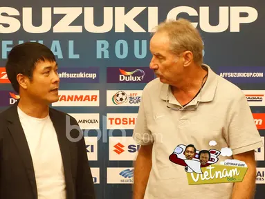 Pelatih Timnas Indonesia, Alfred Riedl (kanan) dan Pelatih Vietnam berbincang saat mengikuti press conference jelang leg kedua semifinal AFF Suzuki Cup 2016 di Vietnam, (06/12/2016). (Bola.com/Peksi Cahyo)