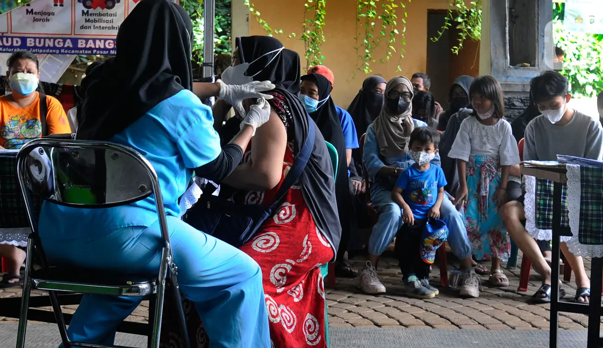 Petugas kesehatan menyuntikan vaksin COVID-19 kepada warga di Balai RW 02, Jati Padang, Jakarta Selatan, selasa (28/6/20222). Munculnya COVID-19 subvarian Omicron BA.4 dan BA.5 membuat sejumlah warga antusias mengikuti vaksinasi COVID-19 yang didominasi vaksin booster.gratis beras, minyak, goreng, gula dan mie instan.  (merdeka.com/Arie Basuki)