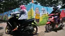 Warga mengendarai sepeda motor melintas di 'Gang Mural', Kelurahan Rorotan, Jakarta, Kamis (29/3). Ide Gang Mural ini diinisiasi oleh Kelurahan Rorotan dan gambar-gambar di sepanjang tembok dilukis oleh petugas PPSU. (Merdeka.com/Iqbal S Nugroho)