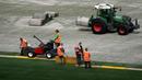 Sejumlah pekerja sedang memasang rumput hybrid baru di Stade de France, Saint-Denis, pada 24 Mei 2022 waktu setempat. Dalam waktu 48 jam, rumput baru yang ditanam di luar Barcelona, dipasang di Stade de France untuk pertandingan final Liga Champions antara Real Madrid dan Liverpool yang dijadwalkan berlangsung pada 28 Mei 2022. (AFP/Franck Fife)
