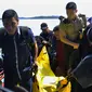 Anggota kepolisian bersiap turun dari kapal sambil mengangkat kantong jenazah berisi puing-puing dan barang-barang dari jatuhnya pesawat jenis M-28 Skytrcuk milik Polri di Pelabuhan Telaga Punggur, Batam, Kepri, Minggu (4/12). (Rezza HERDIYANTO/AFP)