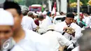 Sejumlah massa aksi makan siang sebelum memulai aksi di Medan Merdeka Timur, Jakarta, Jumat (4/11). Massa melakukan aksi di depan Istana Negara menuntut penegakan hukum kasus dugaan penistaan agama. (Liputan6.com/Faizal Fanani)