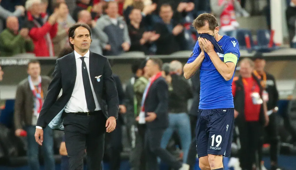 Pelatih Lazio, Simone Inzaghi dan pemainnya, Senad Lulic bereaksi setelah kalah dari Red Bull Salzburg pada leg kedua perempat final Liga Europa di Red Bull Arena, Jumat (13/4). Lazio gagal ke semifinal usai disingkirkan Salzburg 1-4. (KRUGFOTO/APA/AFP)