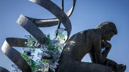 “The Thinker's Burden,” merupakan sebuah paduan patung setinggi 6 meter dari patung ikonik Rodin “The Thinker,” yang dibuat dalam rangka Negosiasi Perjanjian Plastik. Tampak dalam foto, Sebuah karya dari seniman, aktivis, dan fotografer Kanada Benjamin Von Wong berjudul “The Thinker's Burden,” terlihat di depan Kantor Perserikatan Bangsa Bangsa (PBB) di Jenewa, Swiss pada 12 Agustus 2025. (Fabrice COFFRINI/AFP)