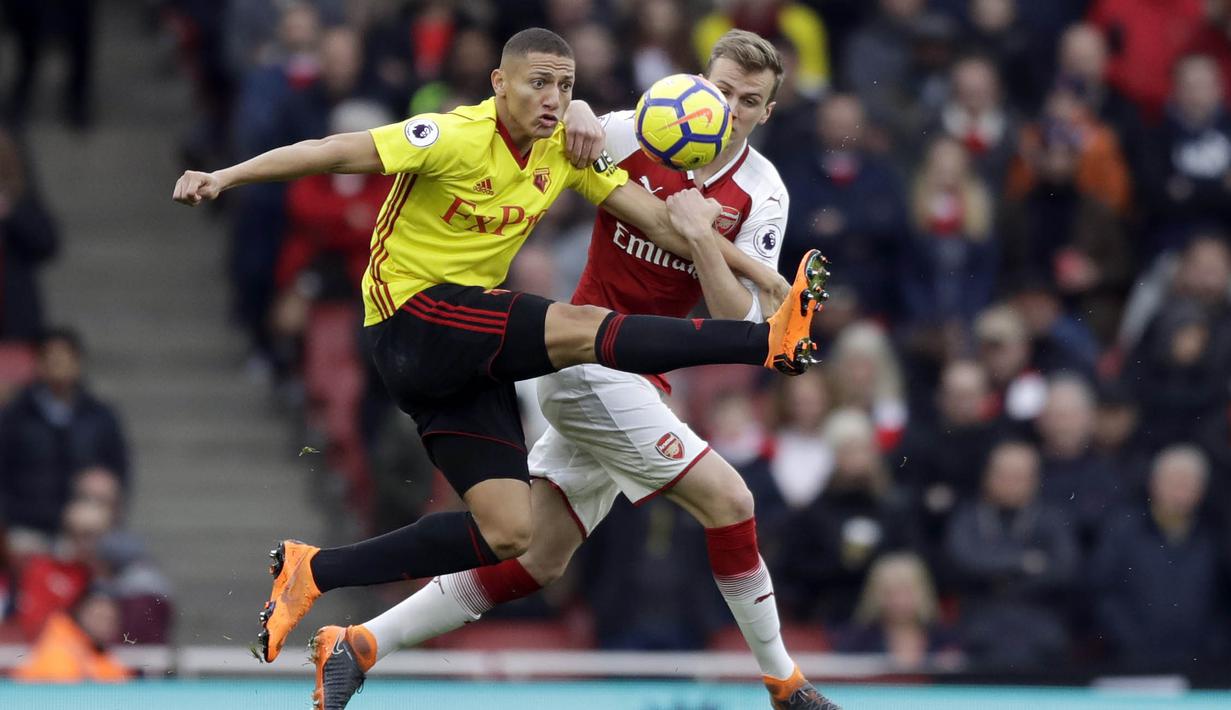 Bek Arsenal, Rob Holding, berebut bola dengan striker Watford, Richarlison, pada laga Preimer League di Stadion Emirates, Minggu (11/3/2018). Arsenal menang 3-0 atas Watford. (AP/Matt Dunham)