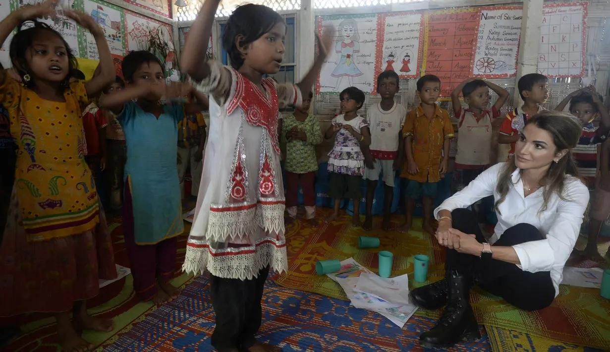 Ratu Yordania Rania menyaksikan anak-anak Rohingya menari di sekolah sementara di kamp pengungsi Kutupalong, Ukhia (23/10). (AFP Photo/Tauseef Mustafa)