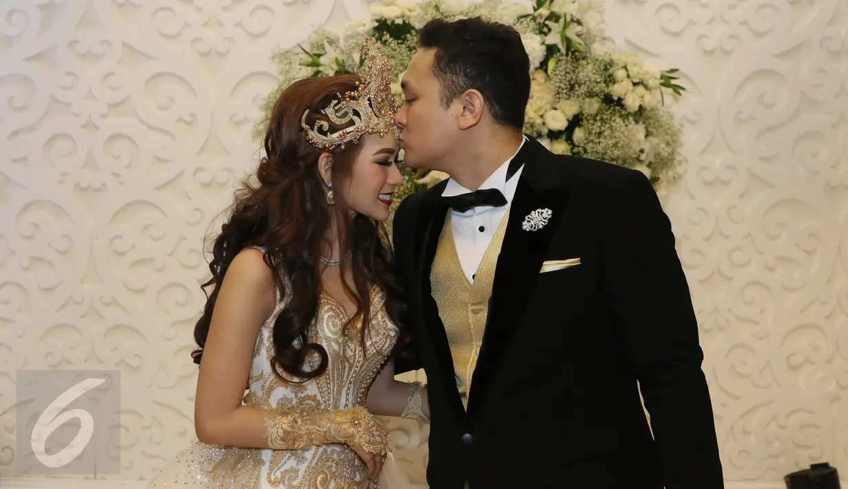 Presenter Gilang Dirga mencium kening istrinya, Adiezty Fersa seusai jumpa pers pernikahan mereka di Kelapa Gading, Jakarta, Minggu (18/9). Gilang Dirga mempersunting Adiezty dengan mas kawin uang tunai sebesar Rp 300.314. (Liputan6.com/Herman Zakharia)