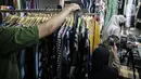 Pedagang menjualkan pakaian melalui melalui aplikasi online di Pasar Tanah Abang, Jakarta, Rabu (1/7/2020). Pedagang di Pasar Tanah Abang mulai menjual barang secara daring untuk menambah penjualan dan mengantisipasi turunnya jumlah pembeli di masa PSBB Transisi ini. (Liputan6.com/Faizal Fanani)