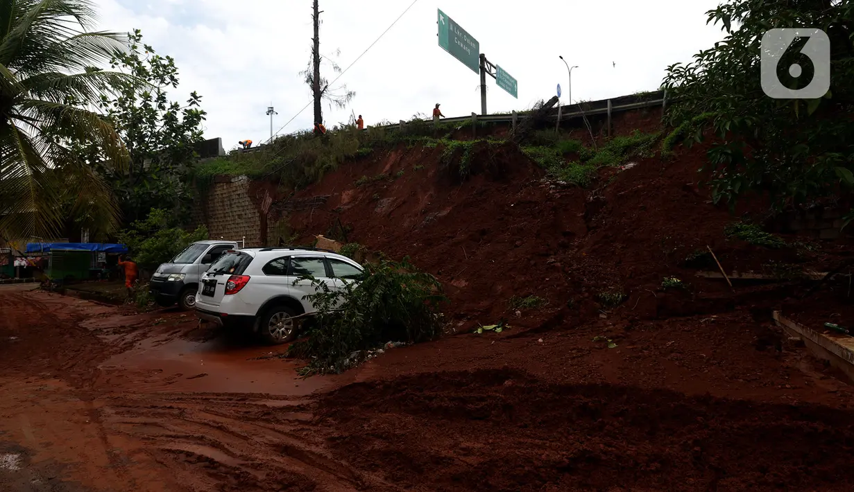 Dua mobil tertimpa longsoran dinding ruas jalan Tol JORR Cikunir, Bekasi, Jawa Barat, Kamis (2/1/2020). Hujan deras pada malam Tahun Baru 2020 membuat sejumlah titik jalan tol rawan longsor dan banjir. (merdeka.com/Imam Buhori)