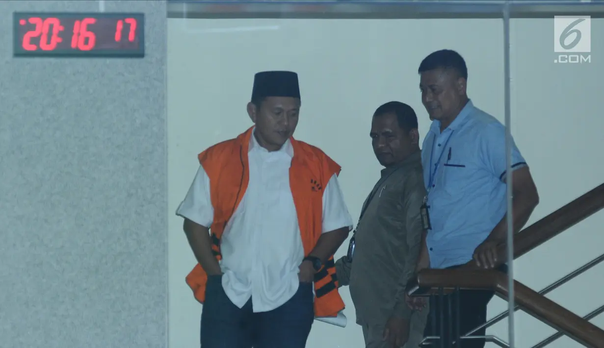 Bupati Lampung Tengah Mustafa (kiri) tertunduk saat menuruni tangga Gedung KPK, Jakarta, Selasa (20/2). Mustafa diperiksa sebagai saksi dugaan suap persetujuan pinjaman daerah untuk APBD Lampung Tengah TA 2018. (Liputan6.com/Helmi Fithriansyah)