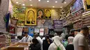 Jemaah haji memilih sajadah yang dipajang di sebuah toko di kota suci Makkah, Arab Saudi pada Selasa (6/8/2019). Puncak Ibadah haji masih beberapa hari lagi, namun jemaah sudah memborong aneka barang antara lain tasbih, baju, teko emas, kurma, sajadah, minyak wangi dan lainnya. (FETHI BELAID/AFP)