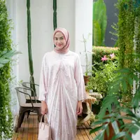 Nina Zatulini memilih kaftan pink pastel dengan motif minimalis yang memberi kesan anggun. Kaftan tersebut dipadukan dengan kulot warna putih. [@ninazatulini22]