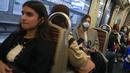 Seorang perempuan yang mengenakan masker menaiki kereta bawah tanah di Paris, Prancis, Kamis (30/6/2022). Dengan turis memadati Paris dan kota-kota lain, pemerintah Prancis merekomendasikan untuk kembali mengenakan masker di transportasi umum dan area ramai tetapi tidak memberlakukan aturan baru. (AP Photo/Michel Euler)