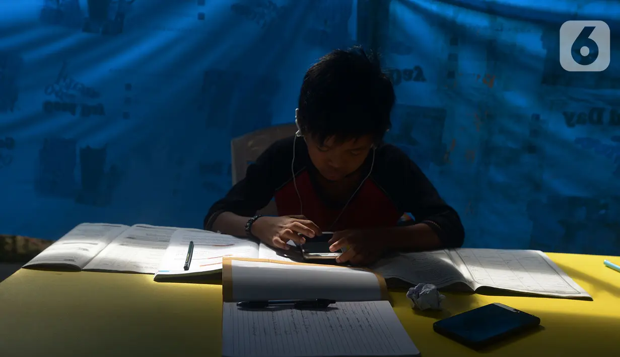 Seorang siswa belajar online di Tenda Wifi gratis di taman warga RT 013, Jakarta Timur, Rabu (12/8/2020). Tenda belajar tersebut menyediakan fasilitas wifi gratis bagi anak-anak sekolah yang terkendala dengan mahalnya kuota internet. (merdeka.com/Imam Buhori)