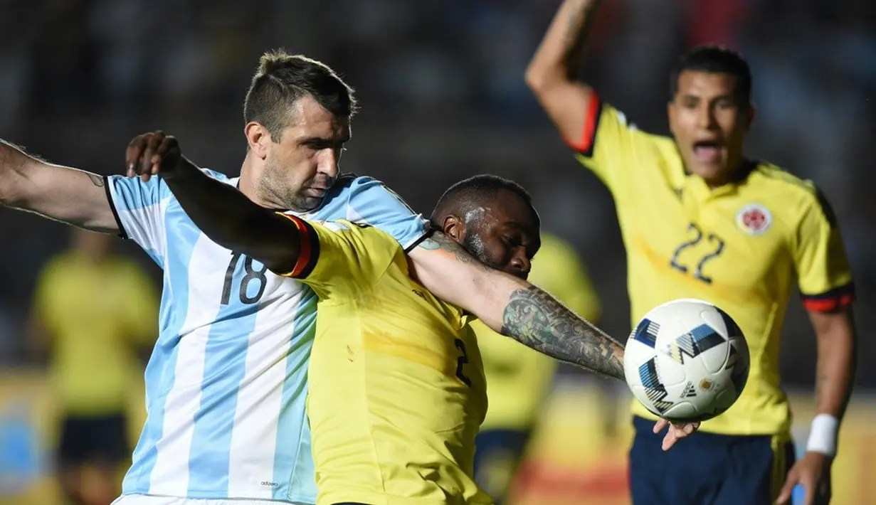 Pemain Argentina, Lucas Pratto (kiri), berebut bola dengan pemain Kolombia, Eder Alvarez, pada laga kualifikasi Piala Dunia 2018 zona CONMEBOL di Estadio San Juan del Bicentenario, Selasa (15/11/2016). (AFP/Eitan Abramovich)