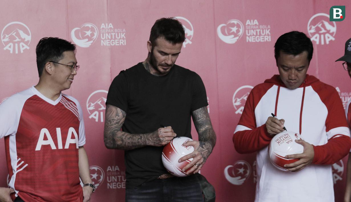 Legenda sepak bola Inggris, David Beckham, dan Menpora RI, Imam Nahrawi, menandatangani bola di Stadion Soemantri Brodjonegoro, Jakarta, Minggu (25/3/2018). AIA membagikan 10.000 bola kepada akademi sepak bola di Indonesia. (Bola.com/M Iqbal Ichsan)