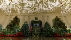Ruangan The Grand Foyer dan Cross Hall dihiasi sejumlah pohon cemara yang didekorasi untuk perayaan Natal di Gedung Putih, Washington DC, Senin (26/11). Tema dekorasi yang diangkat tahun 2018 ini adalah 'American Treasures'. (AP/Carolyn Kaster)