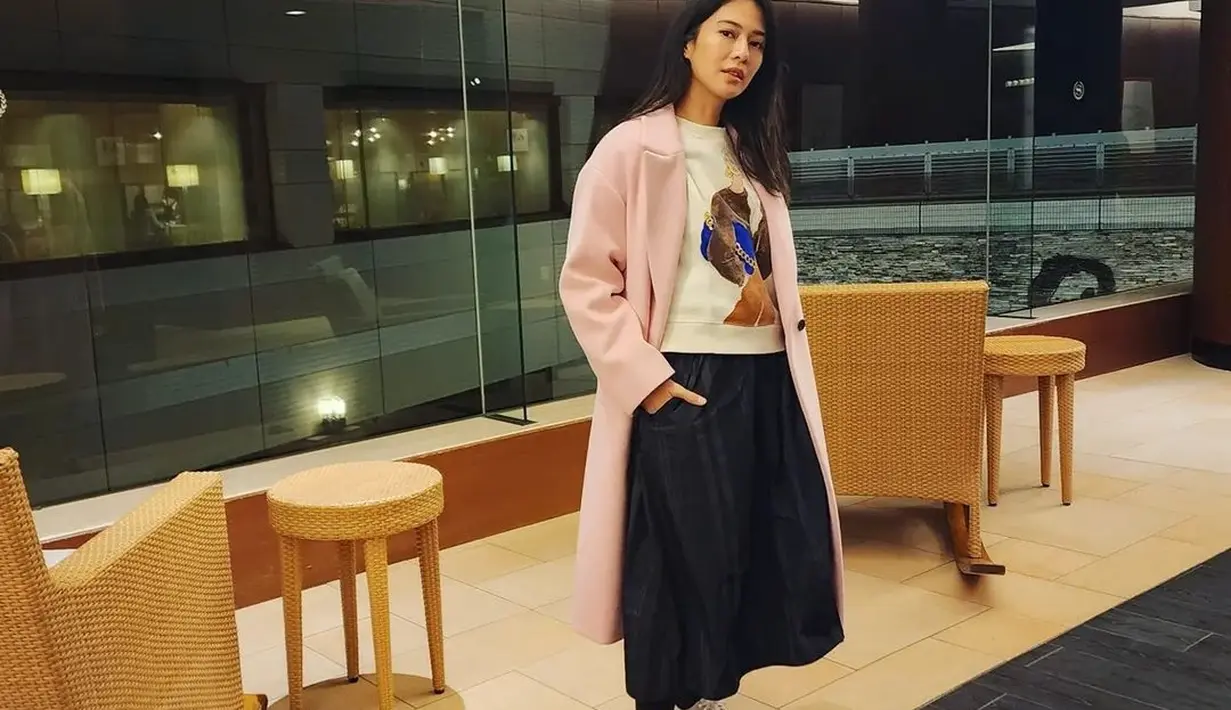 Gaya manis Dian Sastro mengenakan sneakers. Dengan OOTD kasualnya, Dian Sastro memilih mengenakan sweater putih bermotif, ditumpuknya dengan long coat berwarna merah muda, rok midi hitam, kaus kaki panjang hitam, dan sneakers putih. Foto: Instagram.