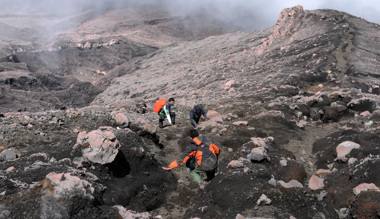 Diperlukan konsentrasi khusus dan fisik yang prima saat melewati jalur terjal berbatu jelang puncak Gunung Kerinci. Tampak beberapa pendaki saat mencoba melintasi jalur di lereng Gunung Kerinci pada 15 Mei 2015. (Liputan6.com/Helmi Fithriansyah)