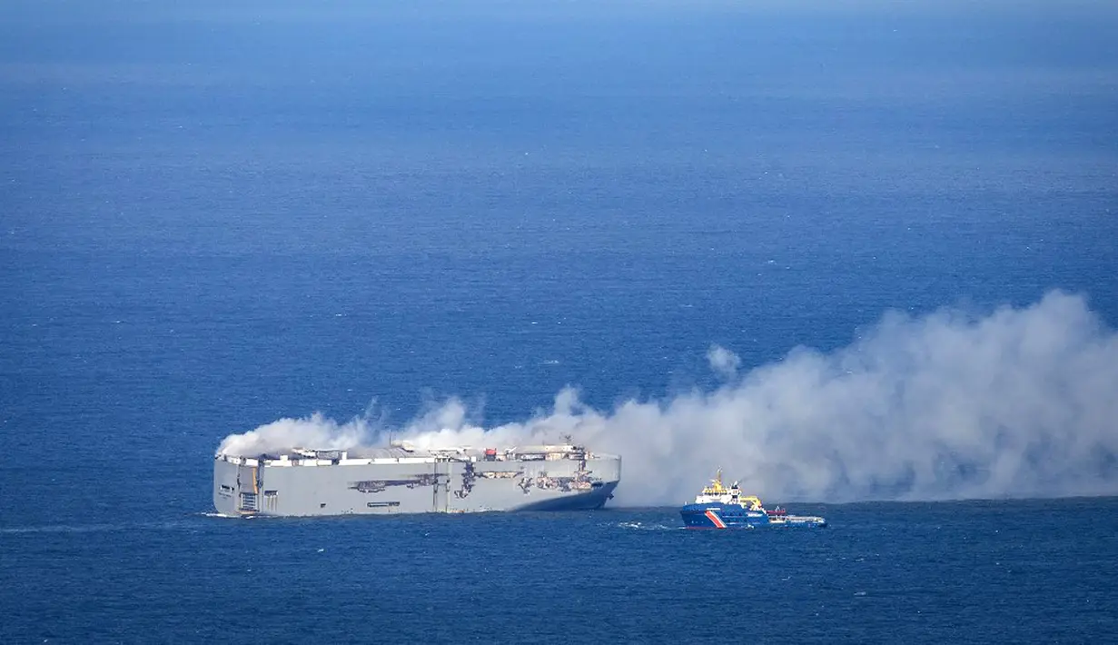 Kapal penyelamat menyemprotkan air ke kapal yang terbakar untuk mendinginkannya, tetapi menggunakan terlalu banyak air berisiko tenggelam, kata penjaga pantai Belanda. Kapal nahas itu melekat pada kapal penyelamat untuk mencegahnya hanyut. (Jan Spoelstra/ANP/AFP)