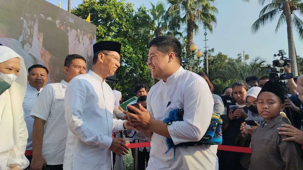 Penjabat (Pj) Gubernur DKI Jakarta Heru Budi Hartono salam-salaman dengan Aparatur Sipil Negara (ASN) dan warga DKI Jakarta yang menggelar Salat Idul Fitri 1444 H di Lapangan Balai Kota DKI Jakarta, Sabtu (22/4/2023).
