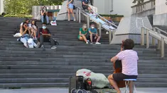 Sejumlah orang yang mengenakan masker mendengarkan musik yang ditampilkan oleh seorang seniman jalanan di Brussel, Belgia (5/8/2020). Kota Brussel memperluas aturan wajib pakai masker di wilayahnya hingga termasuk di jalan-jalan yang ramai dan zona pejalan kaki. (Xinhua/Zheng Huansong)
