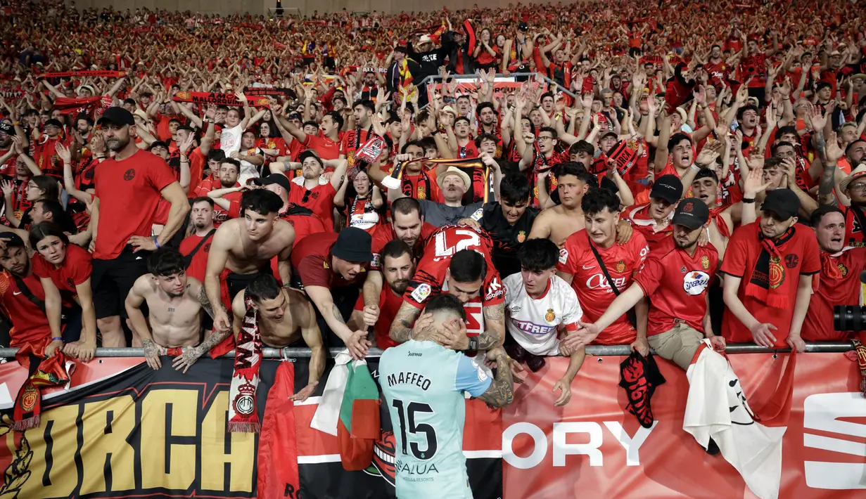 Suporter Real Mallorca berusaha menenangkan Pablo Maffeo yang menangis setelah ditaklukkan Athletic Bilbao pada laga final Copa del Rey di Stadion Olimpico de Sevilla, Minggu (7/4/2024).  Real Mallorca ditaklukkan Athletic Bilbao lewat babak adu penalti. (AFP/Jaime Reina)