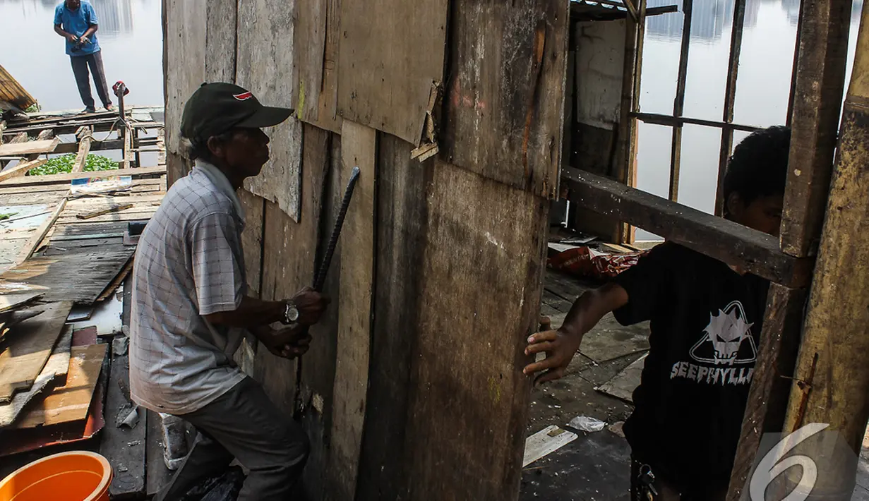 Tanpa bantuan petugas, para warga membongkar rumah mereka sendiri di bantaran Waduk Pluit, Jakarta, Rabu (5/11/2014) (Liputan6.com/Faizal Fanani)