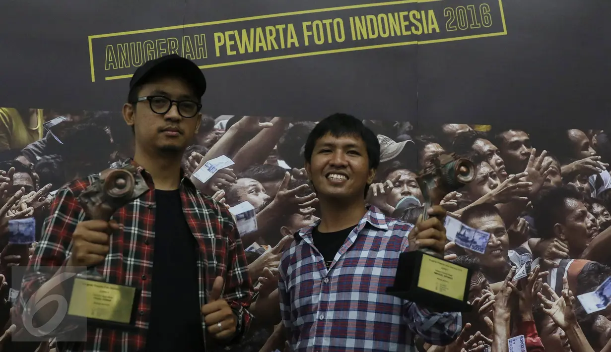 Juara 2 Kategori Spot News pewarta foto Liputan6.com, Faizal Fanani (kiri) dan juara 1 Kategori General News, Immanuel Antonius berpose memegang trofi Anugerah Pewarta Foto Indonesia (APFI) ke-VI di Bandung, Sabtu (9/4). (Liputan6.com/Immanuel Antonius)