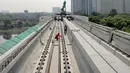 Pekerja mengecek perlintasan LRT di jembatan bentang panjang Dukuh Atas, Jakarta, Rabu (11/11/2020). Jembatan bentang panjang hari ini melakukan pengecoran terakhir panjangnya 128 meter. pekerjaan ini menandai selesainya pengerjaan lintasan atas LRT Jabodebek tahap I. (Liputan6.com/Faizal Fanani)