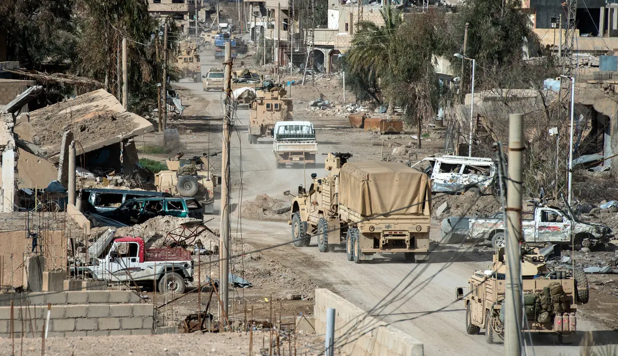 Kendaraan koalisi yang dipimpin Amerika Serikat (AS) menuju garis depan untuk memburu ISIS di kantong terakhir kekhalifahan di Baghouz, Suriah, Minggu (17/2). Wilayah kekuasaan ISIS di Suriah diperkirakan hanya tinggal 700 meter persegi. (Fadel SENNA/AFP)