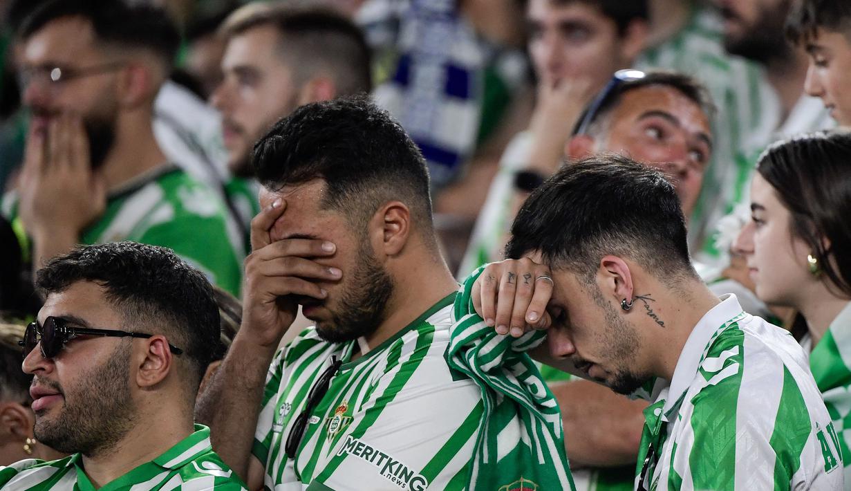 Para fans Real Betis tertunduk lesu setelah timnya kalah dalam laga final UEFA Conference League melawan Chelsea di Tarczynski Arena, Wroclaw, Polandia, Kamis (29/05/2025) dini hari WIB. (AFP/Cristina Quicler)