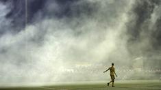 Asap flare yang dinyalakan suporter masuk ke dalam lapangan saat laga Sutton United melawan Arsenal pada putaran kelima Piala FA di Gander Green Lane stadium, London, (20/2/2017). Arsenal menang 2-0. (AP/Matt Dunham)