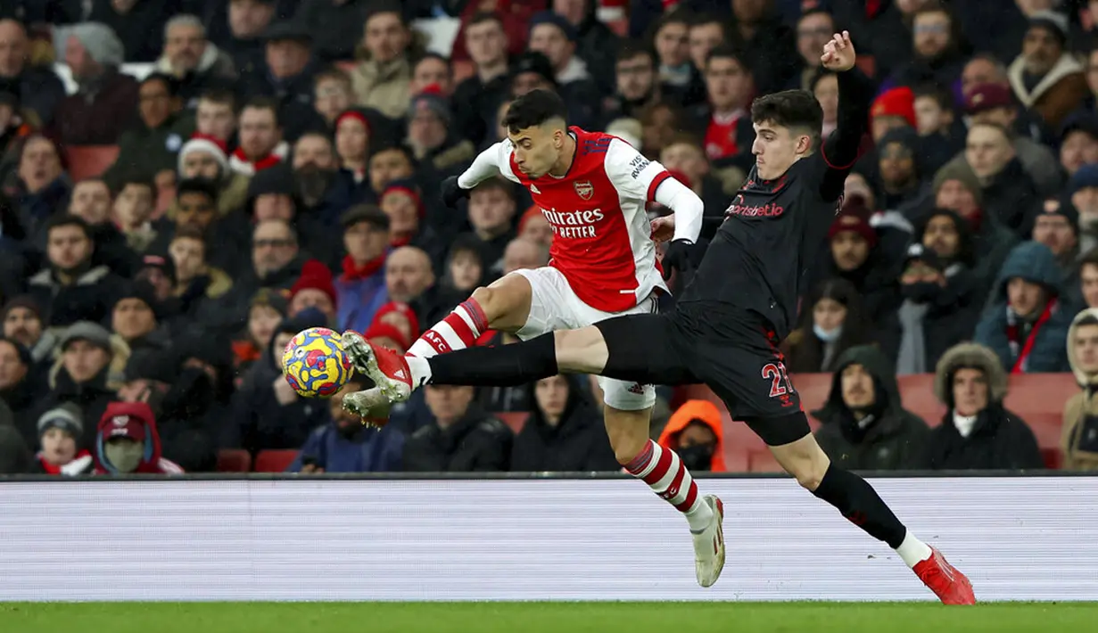 Pemain Southampton Valentino Livramento (kanan) berebut bola dengan pemain Arsenal Gabriel Martinelli pada pertandingan sepak bola Liga Inggris di Emirates Stadium, London, Inggris, 11 Desember 2021. Arsenal menang 3-0. (AP Photo/Ian Walton)