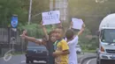Anak-anak  saat meminta bunyi klakson telolet ke bus yang lewat jalan raya A Yani Surakarta, Solo, Kamis (22/12). Fenomena ini mendunia setelah beberapa artis dan tokoh terkenal dunia berkomentar di media sosial. (Liputan6.com/Gholib)