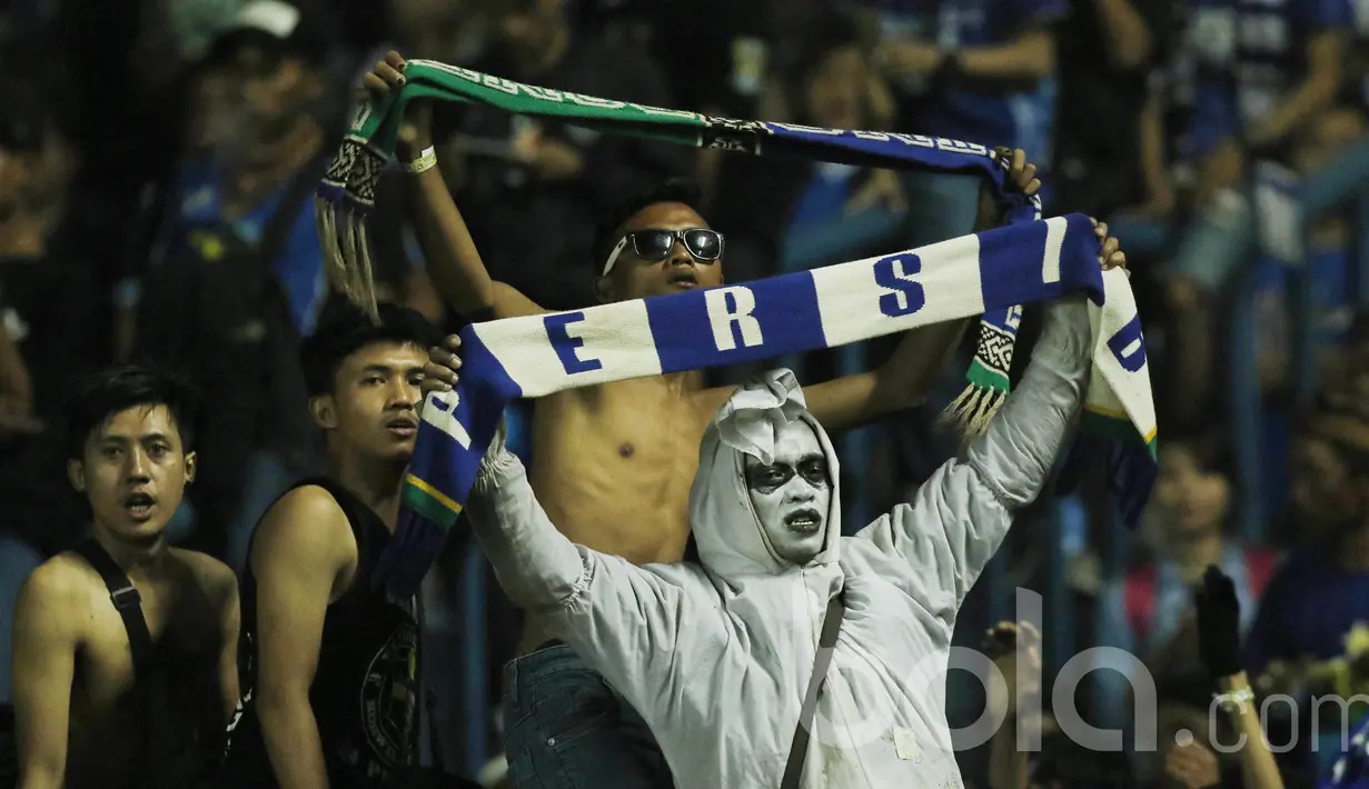 Bobotoh Persib memakai pakaian unik saat mendukung Persib Bandung. Para bobotoh selalu setia mendukung langsung Persib Bandung kala bermain di kandang maupun diluar kandang. (Bola.com/M Iqbal Ichsan)
