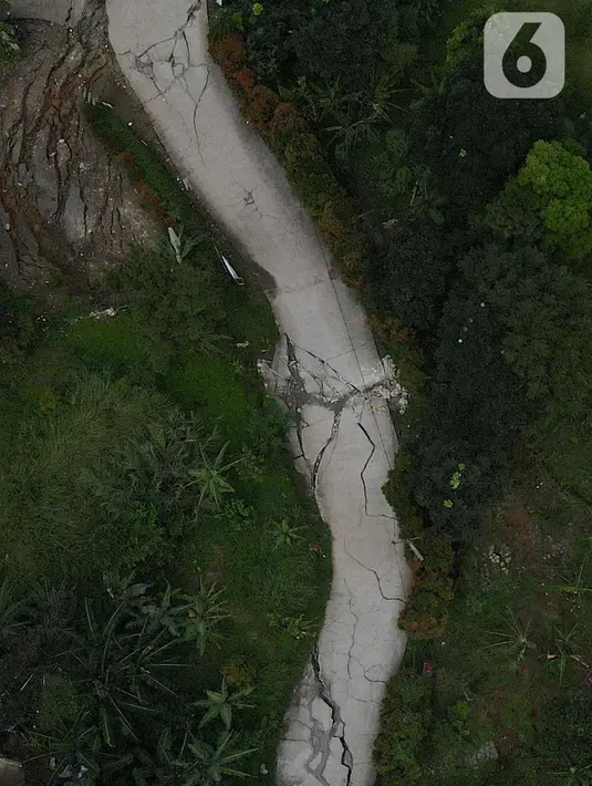Kondisi jalan yang terbelah akibat pergeseran tanah di kawasan Bojong Koneng, Babakan Madang, Kabupaten Bogor, Jawa Barat, Jumat (16/9/2022). Badan Penanggulangan Bencana Daerah (BPBD) setempat mencatat 18 unit rumah mengalami kerusakan, dan pergeseran tanah itu menyebabkan retakan-retakan di tanah, dinding, plafon dan lantai rumah warga serta akses jalan sudah tidak bisa dilewati oleh kendaraan roda dua dan roda empat. (Liputan6.com/Herman Zakharia)