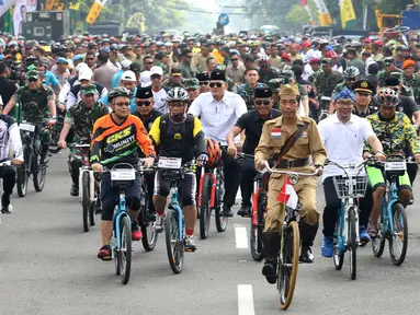 Presiden Joko Widodo atau Jokowi (tengah) didampingi Gubernur Jawa Barat Ridwan Kamil (kanan) saat mengikuti Bandung Lautan Sepeda, Sabtu (10/11). Jokowi menaiki sepeda ontel dalam kegiatan tersebut. (Liputan6.com/Angga Yuniar)