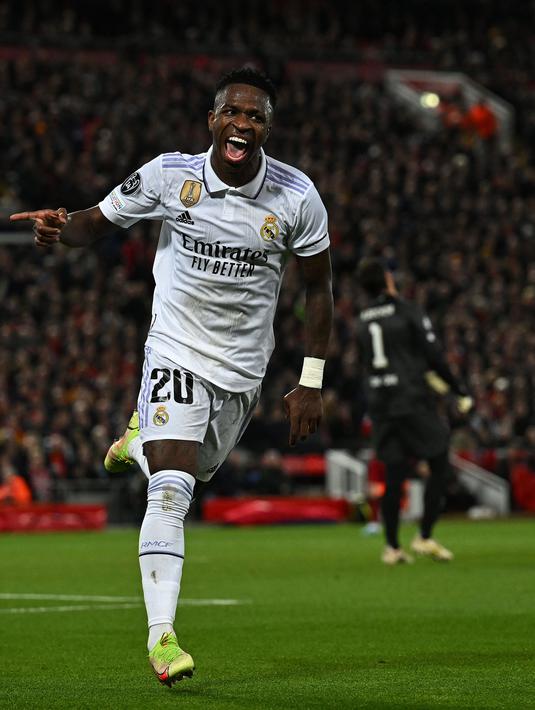 <p>Pemain Real Madrid, Vinicius Jr melakukan selebrasi setelah mencetak gol penyeimbang 2-2 melalui blunder kiper Liverpool, Alisson Becker saat laga leg pertama Liga Champions 2022/2023 melawan Real Madrid yang berlangsung di Anfield, Rabu (22/02/2023) WIB. Liverpool kalah dengan skor 2-5 dari Real Madrid. (AFP/Paul Ellis)</p>