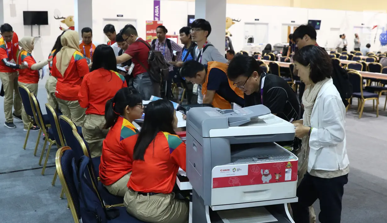 Sejumlah relawan membantu pewarta luar negeri yang akan bertugas meliput Asian Games 2018, JCC, Jakarta, Selasa (14/8). Asian Games 2018 berlangsung hingga 2 September mendatang. (Liputan6.com/Helmi Fithriansyah)