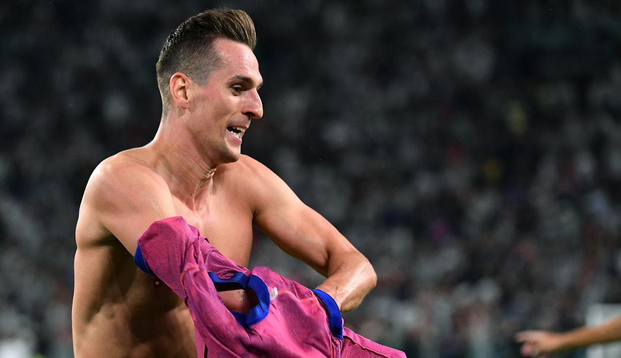 Masih di masa injury time, Juventus kembali membobol gawang Salernitana lewat aksi Arkadiusz Milik. Selebrasi sambil membuka jersey pun akhirnya berbuah kartu kuning kedua untuk Arkadiusz Milik. (AFP/Isabella Bonotto)
