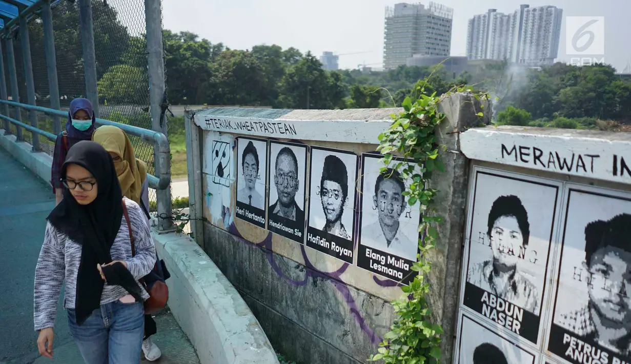 Pejalan kaki melewati poster 13 aktivis yang hilang di kawasan Beji, Depok, Jawa Barat, Selasa (18/6/2019). Poster tersebut mengingatkan masyarakat masih ada pekerjaan rumah pemerintah berupa pelanggaran HAM berat yang belum tuntas hingga kini. (Liputan6.com/Immanuel Antonius)