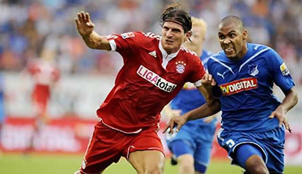 Striker Bayern Muenchen, Mario Gomez (kiri) dikawal ketat bek Hoffenheim, Marvin Compper pada partai Bundesliga TSG Hoffenheim vs Bayern Muenchen di Sinsheim, 8 Agustus 2009. AFP PHOTO/THOMAS LOHNES