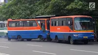 Bus Metromini menunggu penumpang di Jalan Jenderal Sudirman, Jakarta, Rabu (4/7). Larangan bagi Kopaja dan Metromini melintasi jalan protokol selama Asian Games untuk mengurangi kemacetan dan polusi di jalan protokol. (Liputan6.com/Arya Manggala)