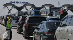 Petugas Kepolisian saat mengatur kendaraan yang masuk ke gerbang Tol Palimanan, Jawa Barat, Selasa (14/7/2015). Hingga H-3 jelang lebaran 2015 pemudik sudah mulai memadati tol Cipali. (Liputan6.com/Herman Zakharia)