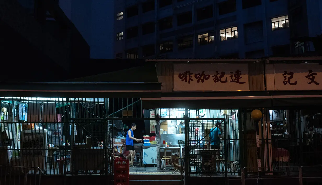 Pekerja menyiapkan makanan di dalam 'dai pai dong' (sebuah restoran terbuka) pada subuh hari di distrik Kwai Chung, Hong Kong (25/5/2019). Kwai Chung adalah situs pelabuhan peti kemas. Ini juga merupakan bagian dari Kota Baru Tsuen Wan. Pada tahun 2000, ia memiliki populasi 287.000. (AFP Photo/Phili