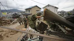 Beberapa Anggota Tentara Bela Diri Jepang terus berupaya melakukan pencarian dan evakuasi korban bencana tanah longsor di wilayah perumahan di Asaminami, Hiroshima, Jepang, (20/8/2014). (REUTERS/Toru Hanai)