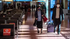 Penumpang berjalan melalui aula kedatangan di Bandara Internasional Haneda Tokyo, Jumat (18/2/2022). Pemerintah Jepang mengumumkan rencana untuk melonggarkan aturan perbatasan virus bagi pekerja dan pelajar. (AFP/Philip Fong)