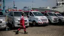 Petugas PMI melintas dekat deretan ambulans yang disiagakan di Posko Evakuasi, Tanjung Priok, Jakarta, Senin (29/10). Posko itu menjadi tempat transit korban jatuhnya pesawat Lion Air JT610 di laut utara Karawang, Jawa Barat. (Liputan6.com/Faizal Fanani)